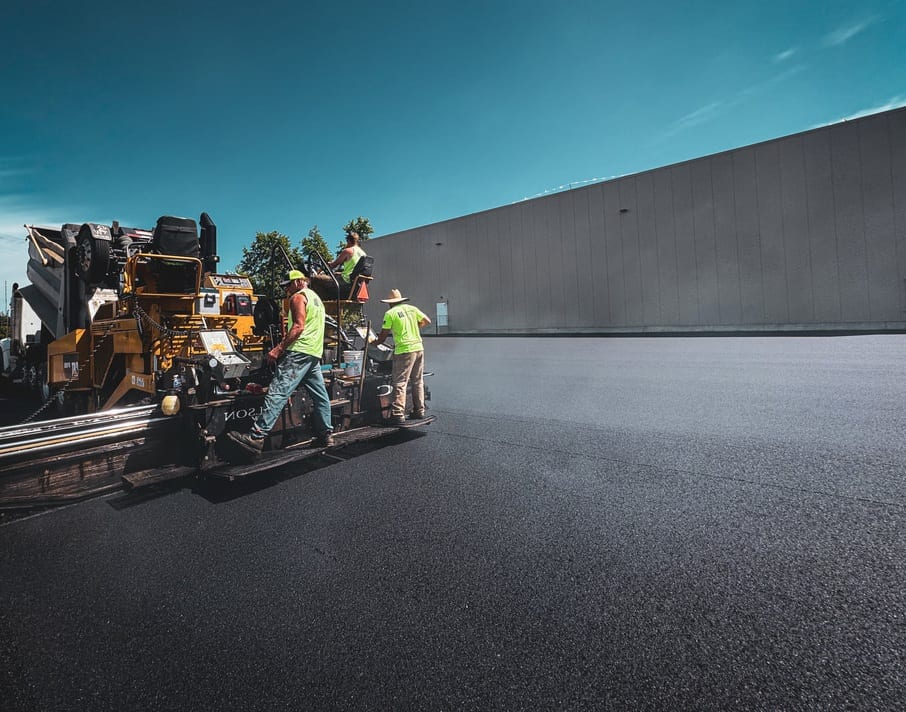 Industrial asphalt paving near a steel frame building